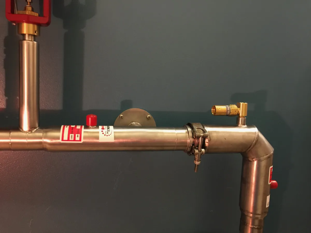 A red vacuum-jacketed proportional LN2 valve feeding a vacuum-jacketed stainless LN2 line