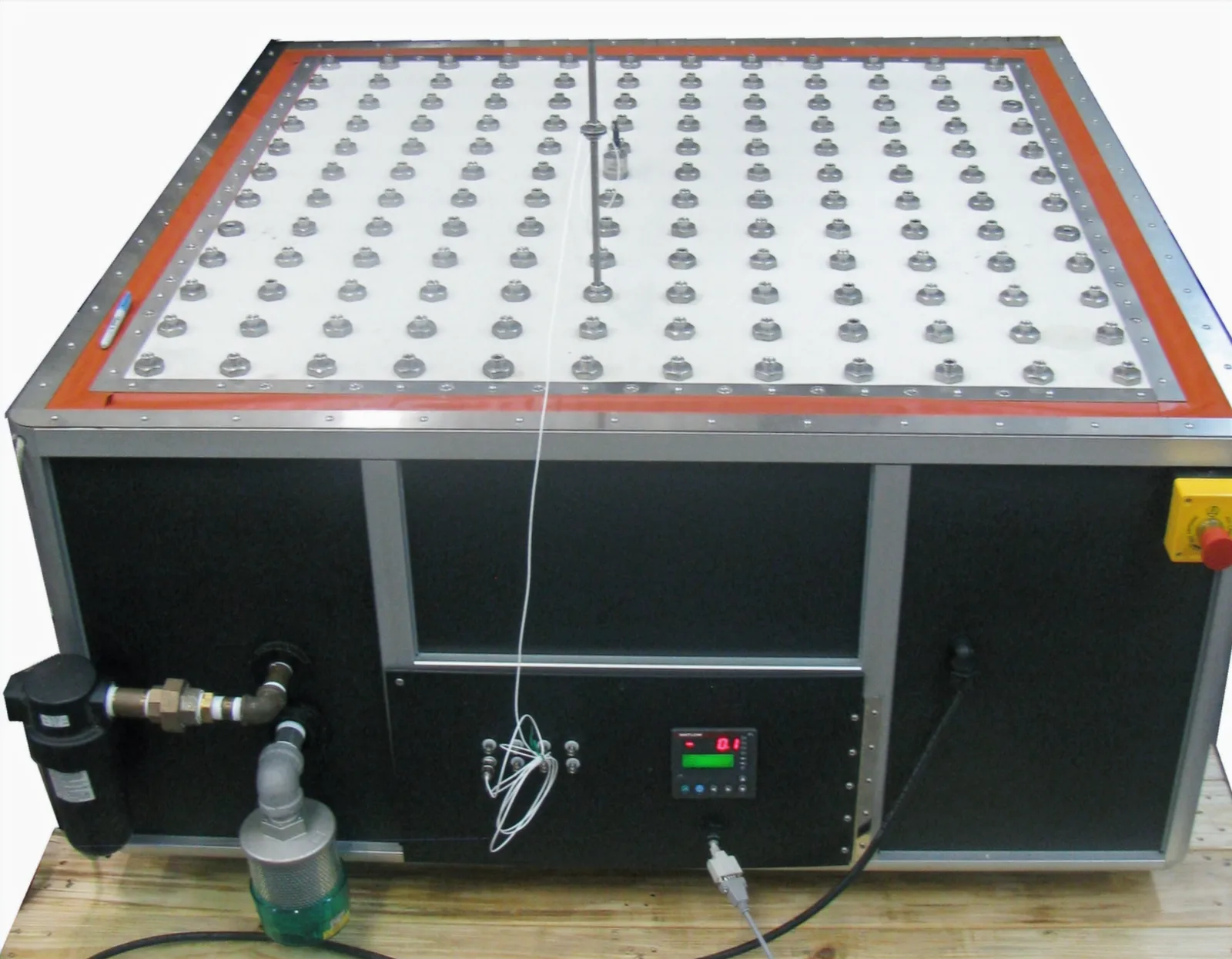 Mesa de vibración cuadrada con una cuadrícula de puntos de fijación sobre una base independiente con su controlador de temperatura