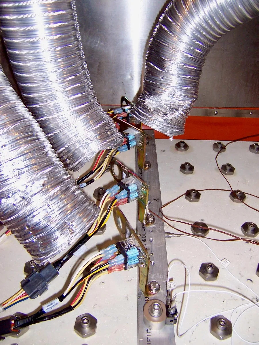 Conductos de aire y cables de acelerómetro dirigidos a un producto sobre una mesa de vibración